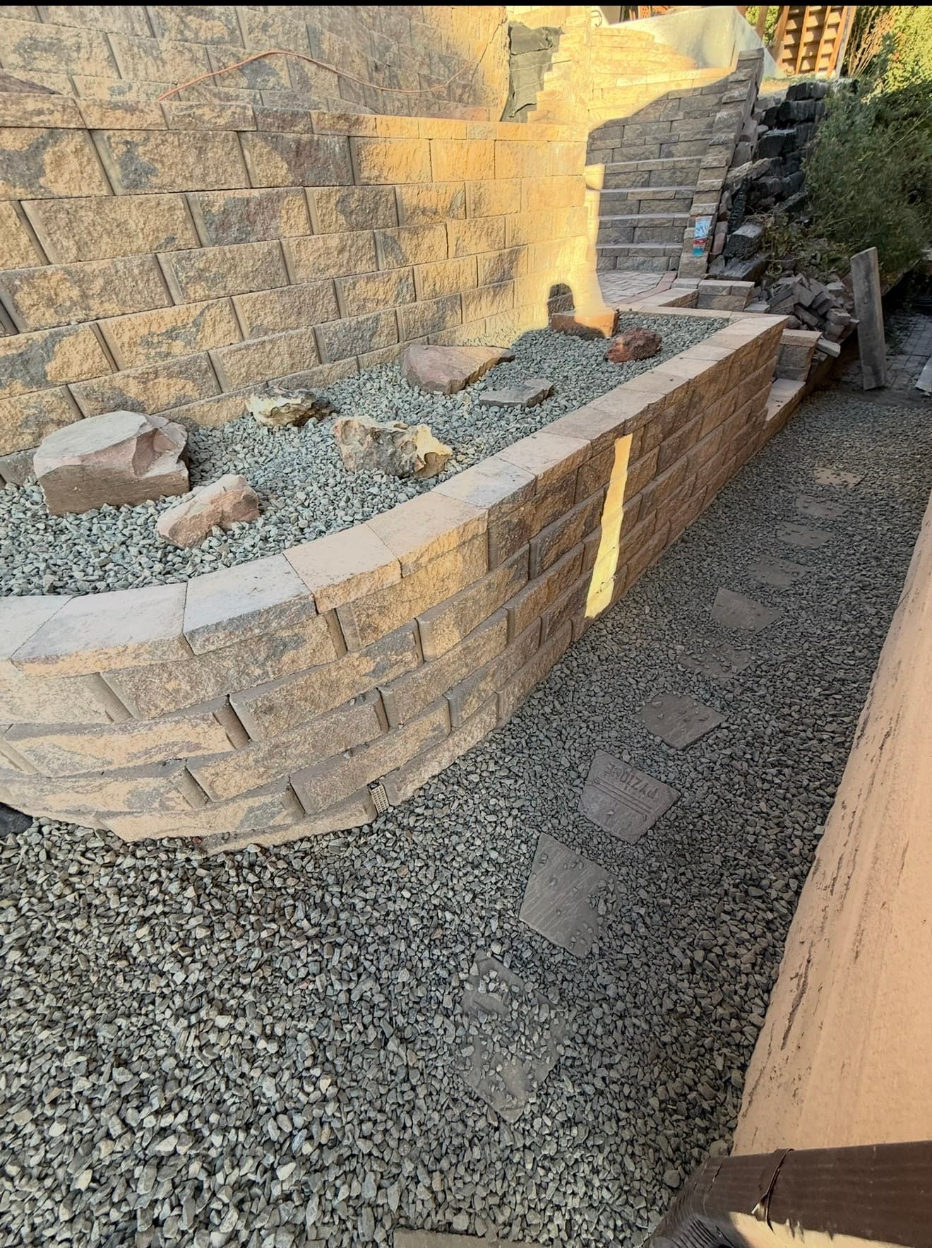 Cheyenne hardscaping: curved retaining walls, gravel beds, and stepping stone path